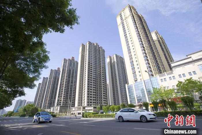 資料圖：車(chē)輛從一樓盤(pán)前經(jīng)過(guò)。 <a target='_blank' href='/'>中新社</a>記者 張?jiān)?攝