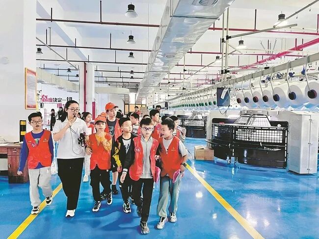 學(xué)生參觀惠安校服企業(yè)生產(chǎn)車間。惠安縣委宣傳部供圖